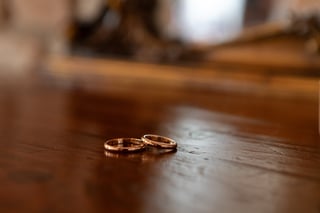 Two golden wedding rings resting on wooden table